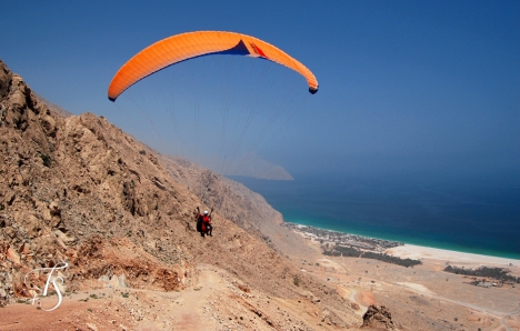 Arrive in style: paragliding into the Six Senses Zighy Bay. ©Travel+Style