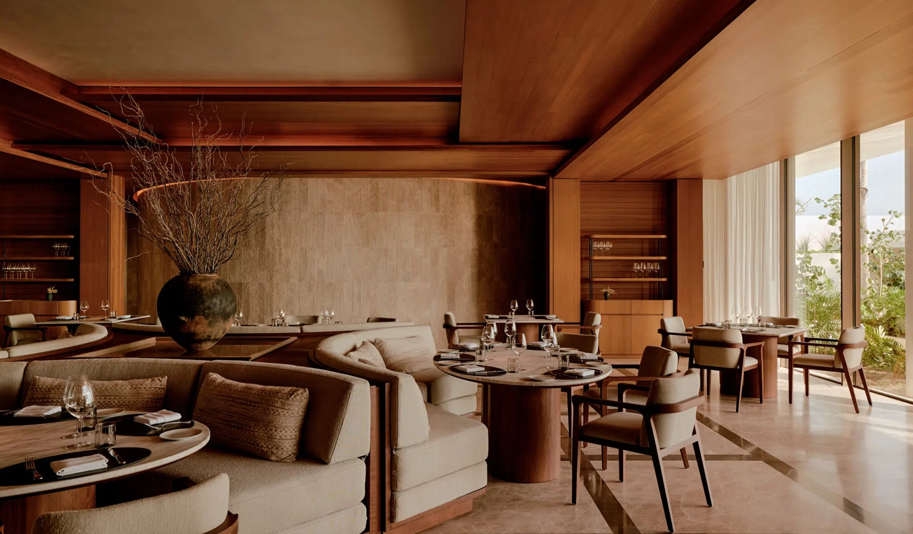 Elegant interior of the luxury restaurant inside Amanvari resort, featuring contemporary Mexican design, warm wooden ceilings, and sophisticated ambient lighting.