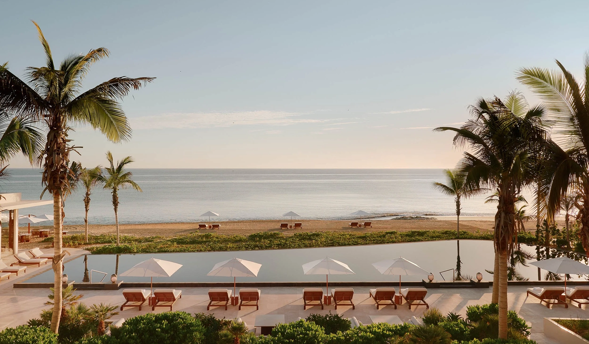 Spectacular infinity swimming pool at the Amanvari hotel in Los Cabos, surrounded by organic architecture and lush desert vegetation.