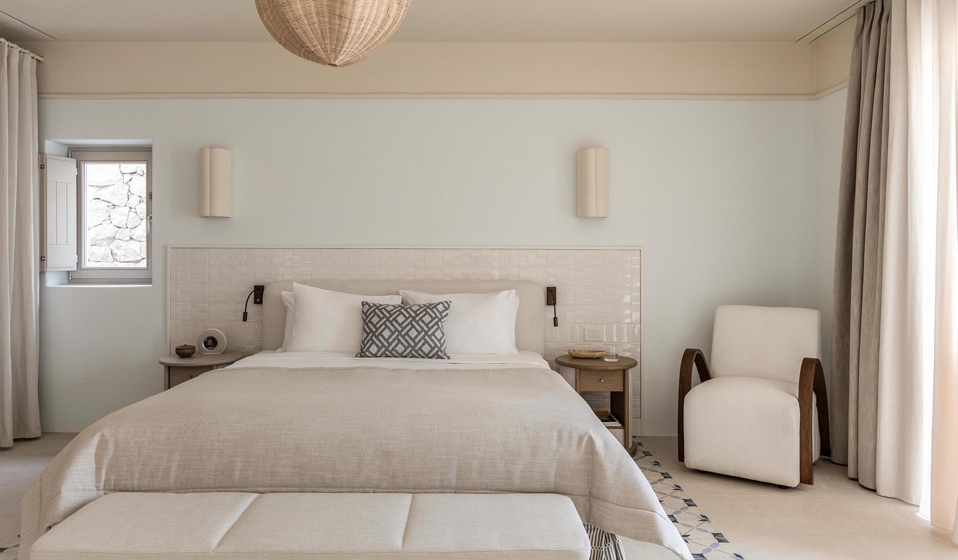Elegant mineral-inspired interior of a luxury suite at Eréma hotel in Milos, featuring natural stone, marble elements, and floor-to-ceiling windows.