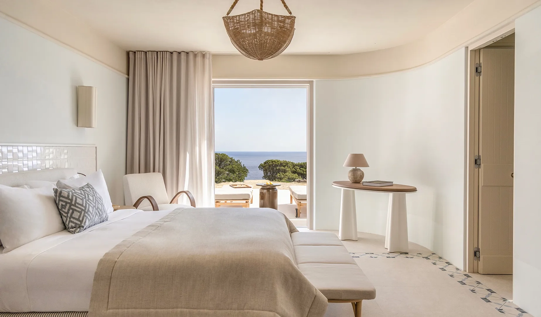 Elegant mineral-inspired interior of a luxury suite at Eréma hotel in Milos, featuring natural stone, marble elements, and floor-to-ceiling windows.