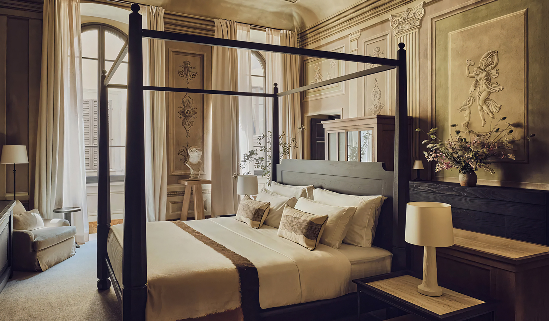 Bedroom at La Réserve Firenze with a wooden four-poster bed beneath an ornate historic ceiling