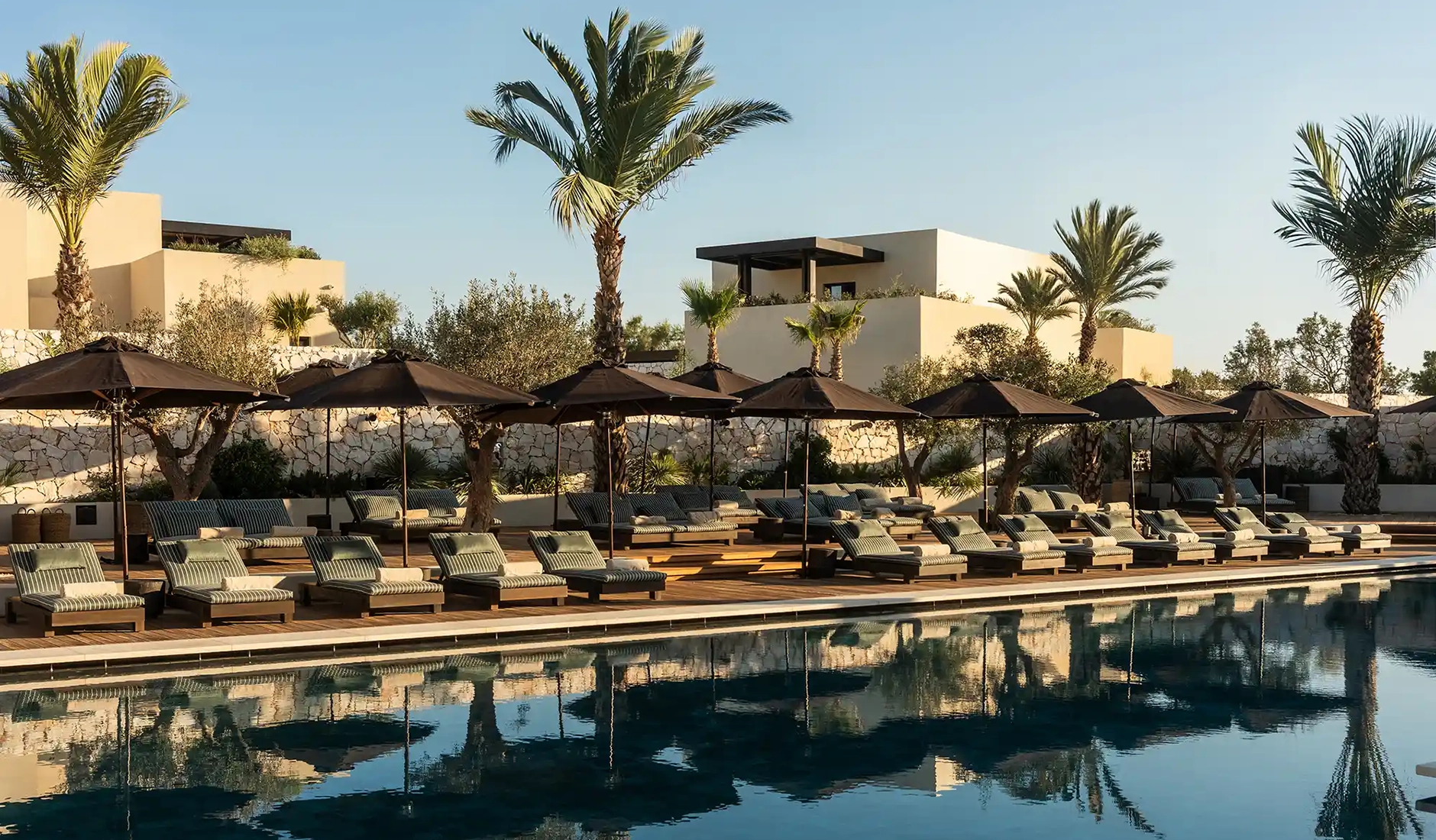 Central swimming pool at Luura Cliff surrounded by white Cycladic-style buildings