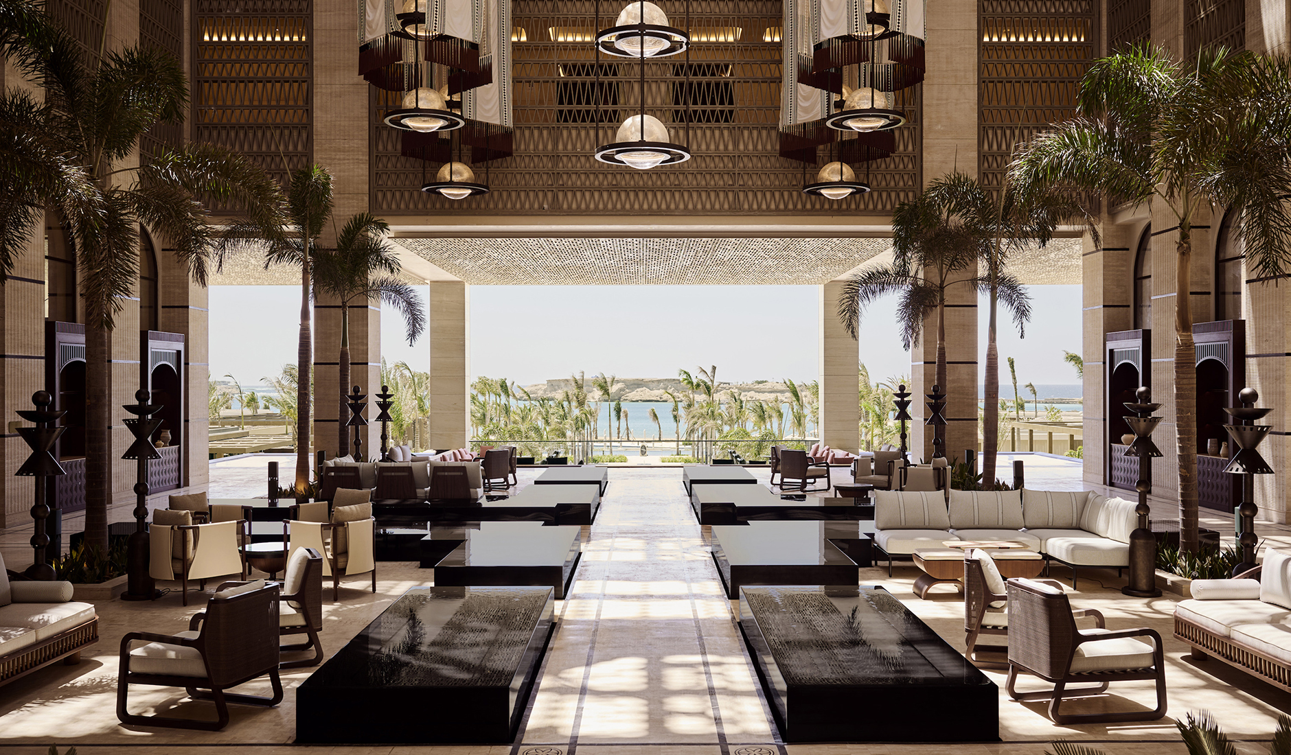 Grand and opulent interior of the lobby lounge at Four Seasons Resort AMAALA at Triple Bay, featuring soaring ceilings, panoramic sea views, and organic interior design.