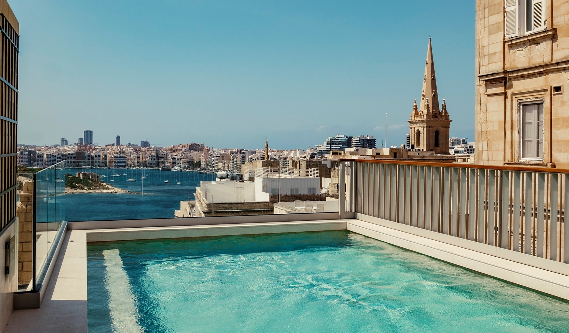 Spectacular rooftop swimming pool at Romègas, ranked among the best luxury hotels in Malta, showcasing an exclusive open-air pool deck with panoramic views over the historic Valletta skyline.