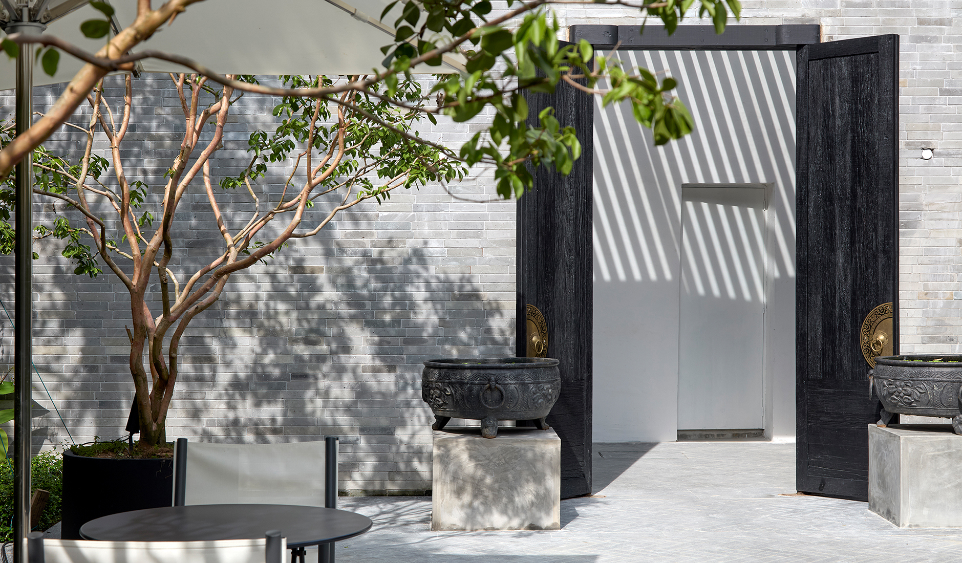 Quiet inner courtyard at Soori Penang, with sculptural greenery and a sheltered atmosphere behind the historic façade
