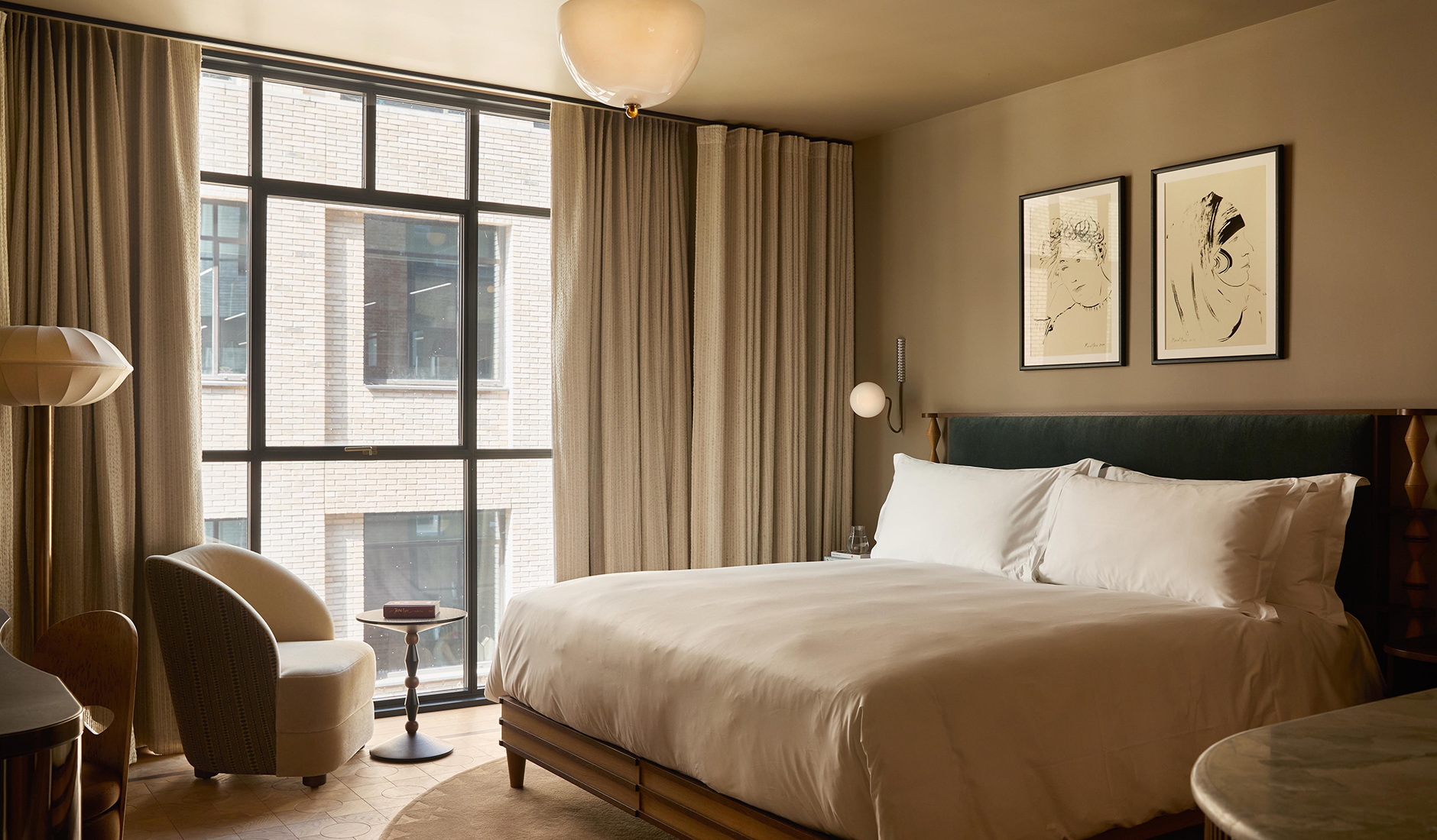 Guest room at The Newman featuring warm wood finishes, patterned textiles and contemporary furnishings