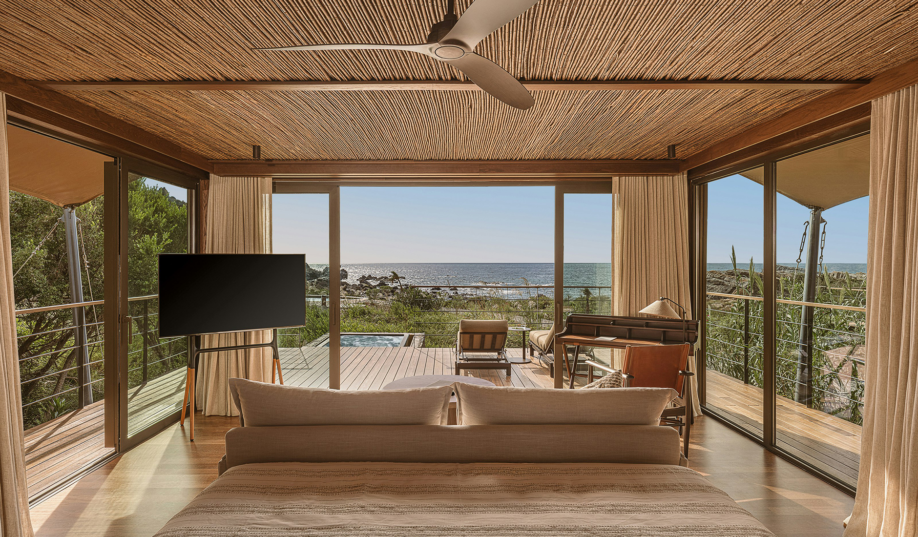 Canvas tented pavilion at The Revery Wild nestled among the vegetation near the shore