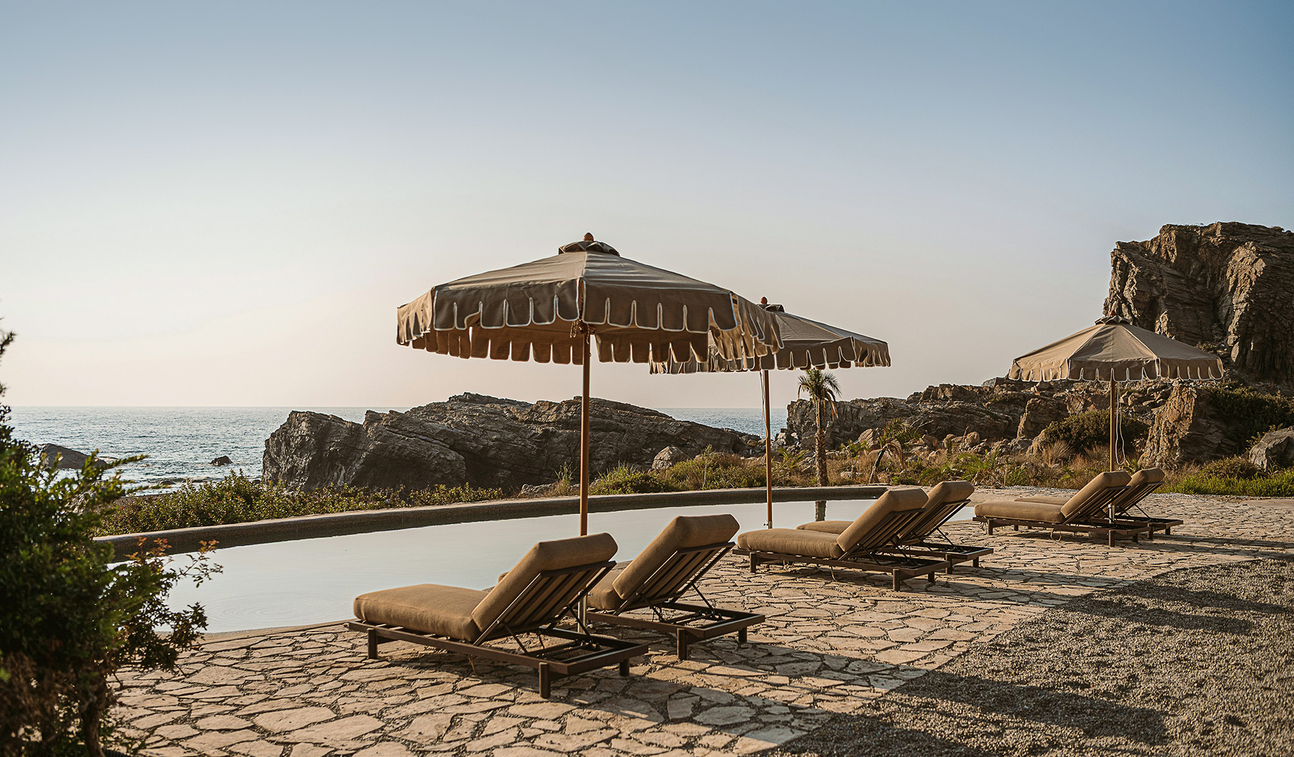 Outdoor pool terrace at The Revery framed by the surrounding rocky landscape