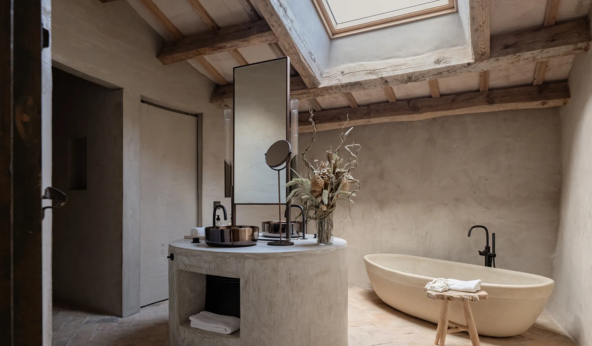 Contemporary bathroom interior inside Vestige Binidufà hotel, featuring freestanding stone bathtub, local marble finishes, and minimalist styling.